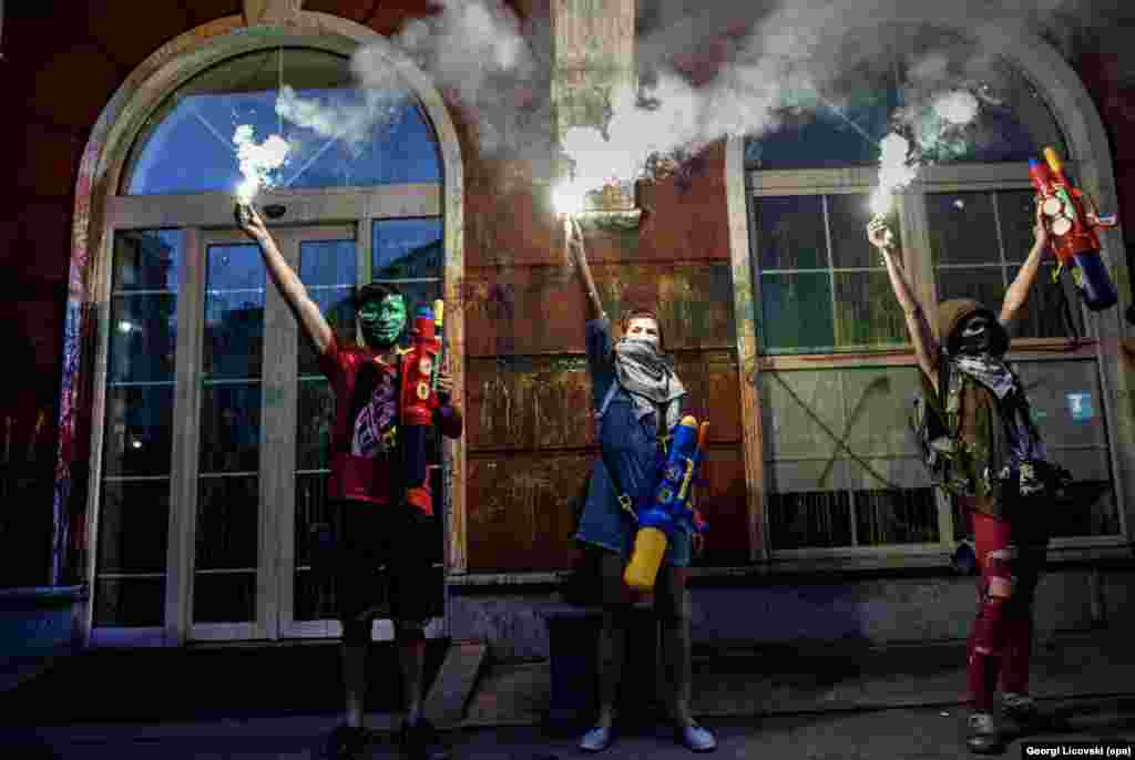 Macedonian protesters light flares after they spray paint on the facade of the Justice Ministry building in Skopje, during an antigovernment protest. (epa/Georgi Licovski) 