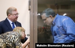 Whelan speaks with lawyers while standing in the defendants' cage in a Moscow courtroom on January 22.