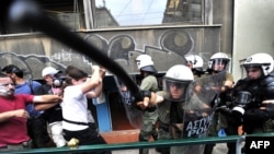 Protesters demonstrating against austerity measures clash with riot police during a general strike in Athens in June.