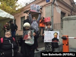 People gathered near a memorial plaque dedicated to Politkovskaya near the Novaya Gazeta offices to register their anger that whoever ordered her killing has not yet been found.