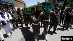 Afghan soldiers carry the coffin of Zabihullah Tamanna, an Afghan journalist who was killed while embedded with local troops last year