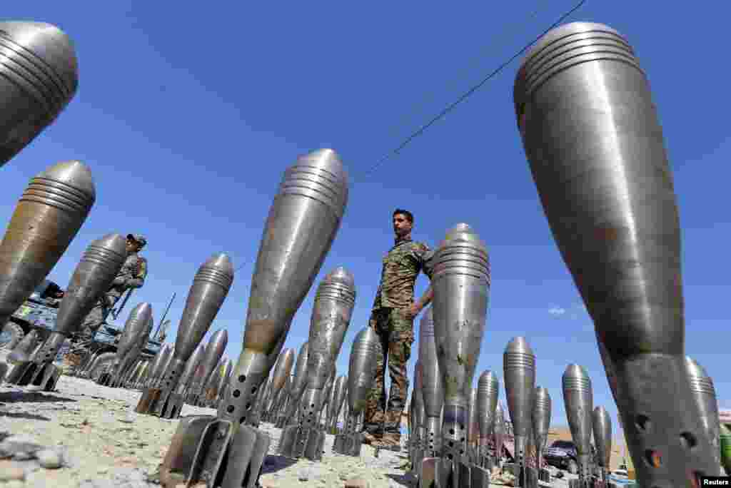 A member of the Iraqi security forces stands between captured Islamic State ammunition being displayed in Al-Alam Salahuddin Province. (Reuters/Thaier Al-Sudani)