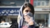 An Iranian woman covers her face, following the coronavirus outbreak, as she walks in Tehran, March 5, 2020