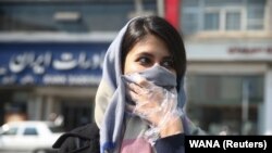 An Iranian woman covers her face, following the coronavirus outbreak, as she walks in Tehran, March 5, 2020