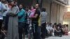 Люди стоят в очереди за хлебом в одном из пригородов Алеппо 