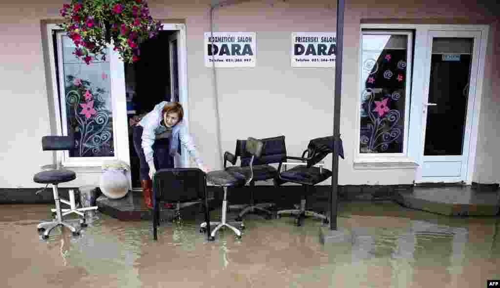 A woman attempts to save furniture from her flooded office in Banja Luka, western Bosnia-Herzegovina.