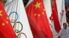 China - A man stands beside the Olympic and Chinese national flags hung to welcome the Olympic torch relay in Kashgar, 18Jun2008