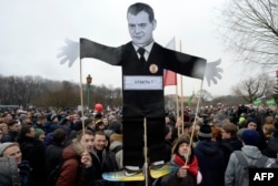Opposition supporters with a cutout figure depicting Prime Minister Dmitry Medvedev participate in an anticorruption rally in St. Petersburg on March 26.