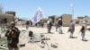 FILE: Taliban militants wave their flag patrol in a rural district of central Afghanistan in May 2017.