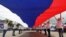Young people hold a giant Russian national flag as they take part in celebrations for the Day of Russia in the southern city of Stavropol, Russia, June 12, 2015. REUTERS/Eduard Korniyenko      TPX IMAGES OF THE DAY