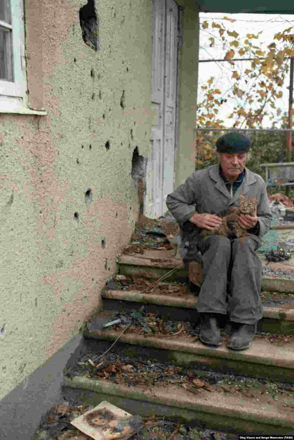 Оқ тескен үйінің жанында отырған бейбіт азамат. Соғыс қысқа ұласқанда, өз бетімен жүрген түрлі жасақтар ауылдарға шабуыл жасаған. 