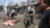 Local residents pass the covered body of an apparent civilian casualty in the village of Stanitsa Luhanskaya, in the eastern industrial province of Luhansk, on July 2.