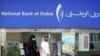 UAE -- An Emirati couple walk past the National Bank of Dubai at a shopping center in the Gulf Emirate, Dubai, 07Mar2007 