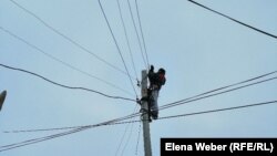 Рабочий энергокомпании на опоре линии электропередачи в поселке Жанаарка Карагандинской области.
