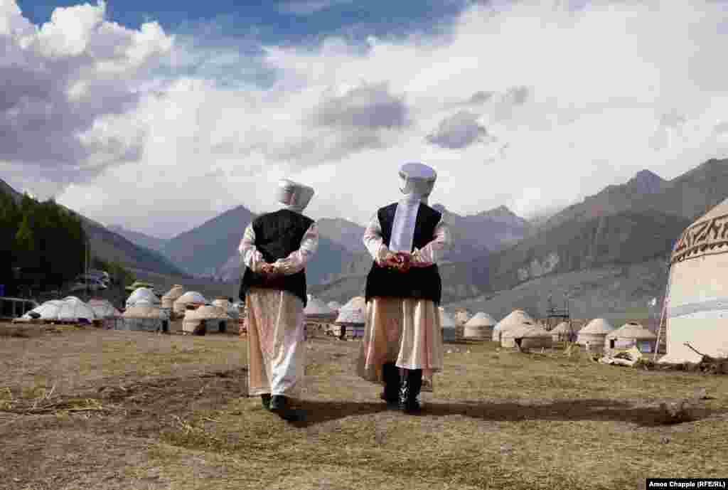 Old friends amble toward their yurt near the end of festivities.