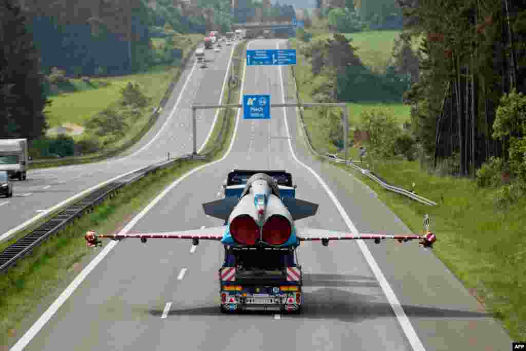 A damaged jet fighter is transported on the back of a truck on a German highway near Plech in southern Germany. It was being transported to a factory after being damaged during a collision with a civil airplane last year. (AFP/dpa/Daniel Karmann)