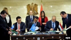 Syrian ambassador to the UN Bashar Jaafari (2-R) signed an agreement with the UN to dispose of its chemical weapons in February 2014.