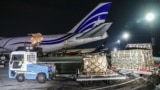 Робітники розвантажують військову допомогу з літака, доставленого зі США до України, у міжнародному аеропорту Бориспіль під Києвом, Україна, 25 січня 2022 року
