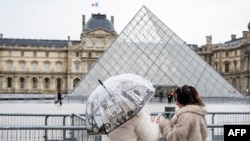  گردشگران در کنار میدان روبه‌روی هرم لوور