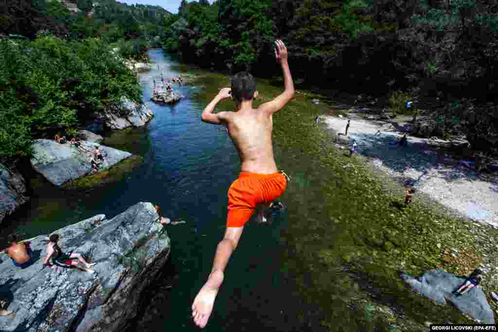 A boy jumps into the River Treska during a hot day, near Skopje in North Macedonia.