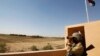 An Iraqi border policeman looks through a pair of binoculars near the Iraqi-Syrian borders at the Abu Kamal-qaim border crossing, the main border post between Iraq and Syria, September 8, 2012