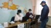 Operatori care verifică codul numeric personal la un centru de votare din Varnița. 1 noiembrie 2020 