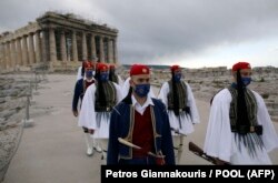 اعضای گارد ریاست جمهوری یونان در حال اجرای مراسم سالگرد استقلال در مقابل معبد پارتنون