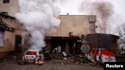 Un pompier stinge un incendiu la un automobil avariat în urma unui atac cu rachete și drone rusești asupra Kievului, 29 noiembrie 2025.
