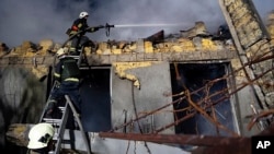 Pompierii ucraineni intervin la o clădire în flăcări după un atac rusesc în Odesa, Ucraina, 23 februarie 2024.