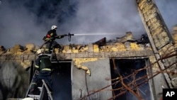 Ukrainian firefighters work on the site of a burning building after a Russian attack in Odesa on February 23.