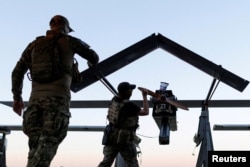 Ukrainian soldiers write messages to Russians on an FP-1 deep-strike drone before it launches for a combat mission. (file photo)