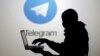 Человек с ноутбуком на фоне логотипа Telegram, иллюстративное фото