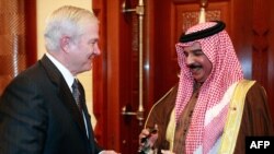 U.S. Defense Secretary Robert Gates (left) presents a bronze eagle statue to Hamad bin Isa Al Khalifa, king of Bahrain, during a visit to Safryia Palace.