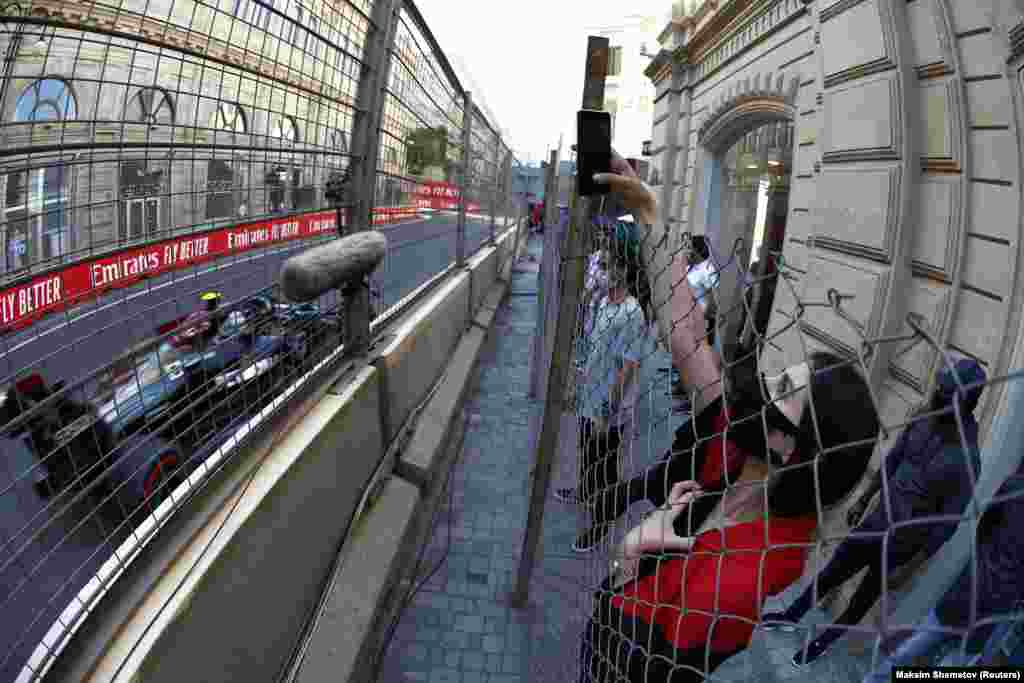 A woman takes a photograph during a practice session ahead of the Formula One Grand Prix in Baku, Azerbaijan.