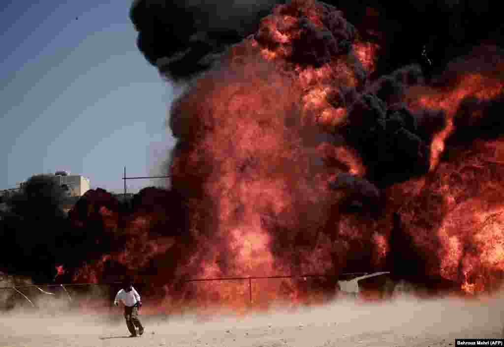 A man who was fixing explosives wires run away after setting ablaze 50 tons of drugs seized in recent months in eastern Tehran. (AFP/Behrouz Mehri)