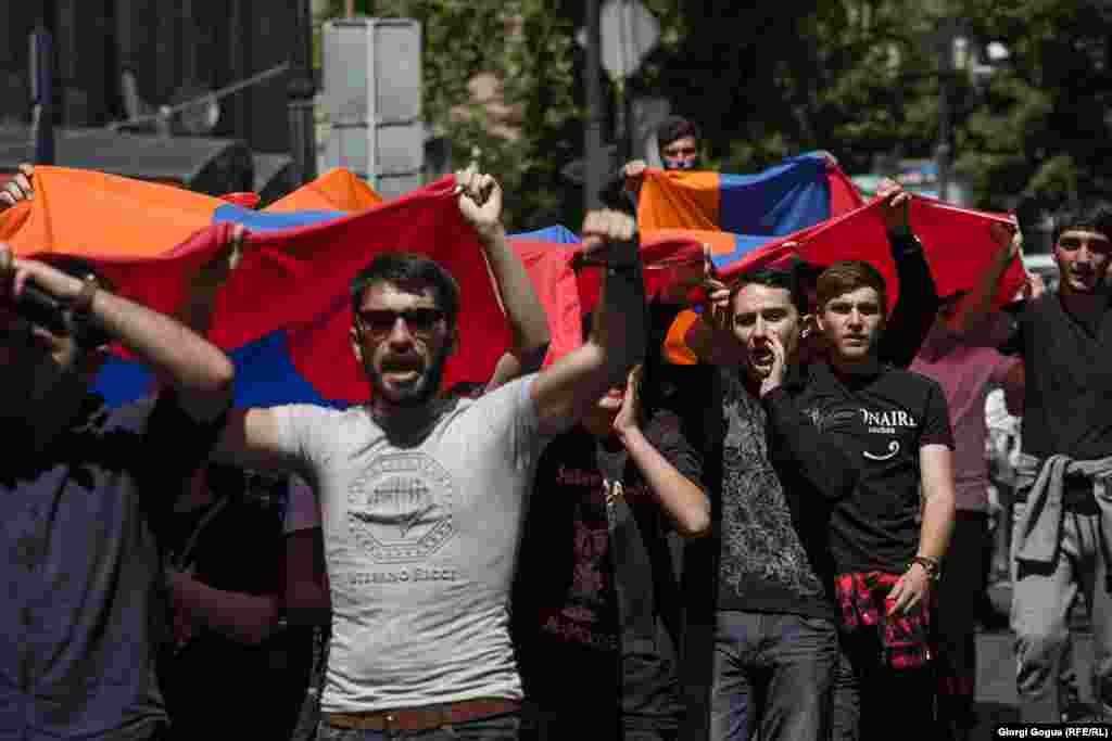 Young supporters of protest leader Nikol Pashinian march with the Armenian flag.