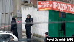 Police officers stand guard outside the candy factory after the shooting in Moscow on December 27.