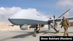 File photo - A U.S. Air Force officer passes in front of a MQ-9 Reaper drone, one of a squadron that arrived to step up the fight against the Taliban, at the Kandahar air base, January 23, 2018