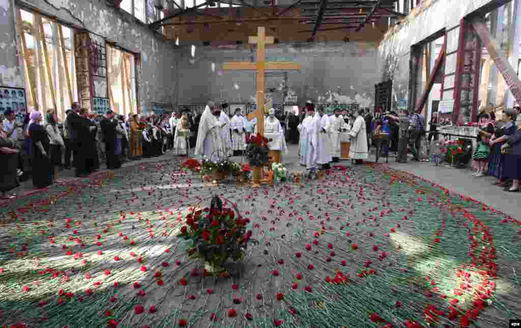 Local residents attend a church service commemorating the victims of the 2004 hostage crisis at a school in the southern Russian town of Beslan. Some 334 people, 186 of them children, were killed and more than 800 injured in the three-day siege.