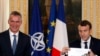 French President Emmanuel Macron (R) holds a diagram of the NATO Europe and Canada defense expenditure during a press conference with NATO Secretary-General Jens Stoltenberg in Paris, December 19, 2017