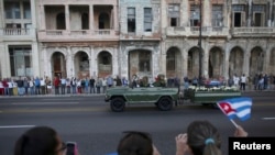 Тысячи людей вышли на улицы в Кубе, чтобы посмотреть на процессию с военным автомобилем, который перевозит прах покойного лидера Кубы Фиделя Кастро. Гавана, 30 ноября 2016 года.
