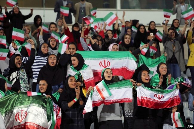 Iranian women cheer during the friendly between Iran and Bolivia at Azadi Stadium in Tehran on October 16.