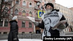 Активист прокремлевского движения раздает листовки в поддержку политики президента Путина