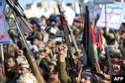 Houthi rebels brandish their weapons as they rally in solidarity with Iran and Lebanon, amid the US-Israeli war with Iran, in the Yemeni capital, Sanaa, on March 27.