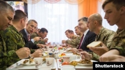 Президент України Петро Порошенко (третій справа) і генеральний секретар НАТО Єнс Столтенберґ (третій зліва) обідають на Яворівському полігоні у Львівській області 21 вересня 2015 року