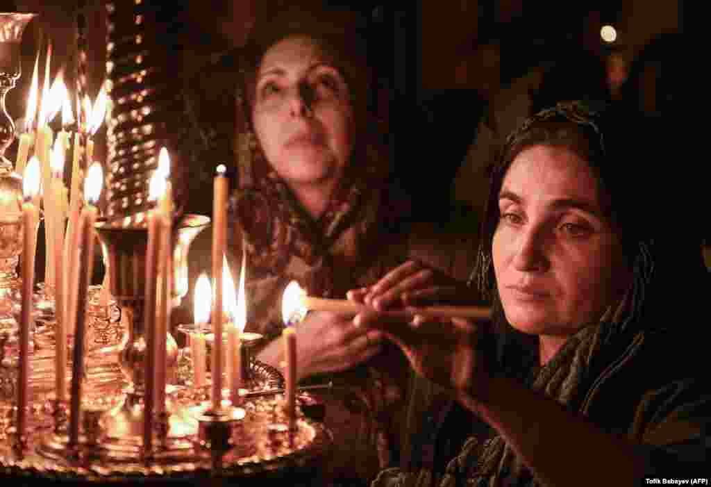 Women light candles during an Orthodox Easter Sunday service in a church in Baku, Azerbaijan, on April 8. (AFP/Tofik Babayev)