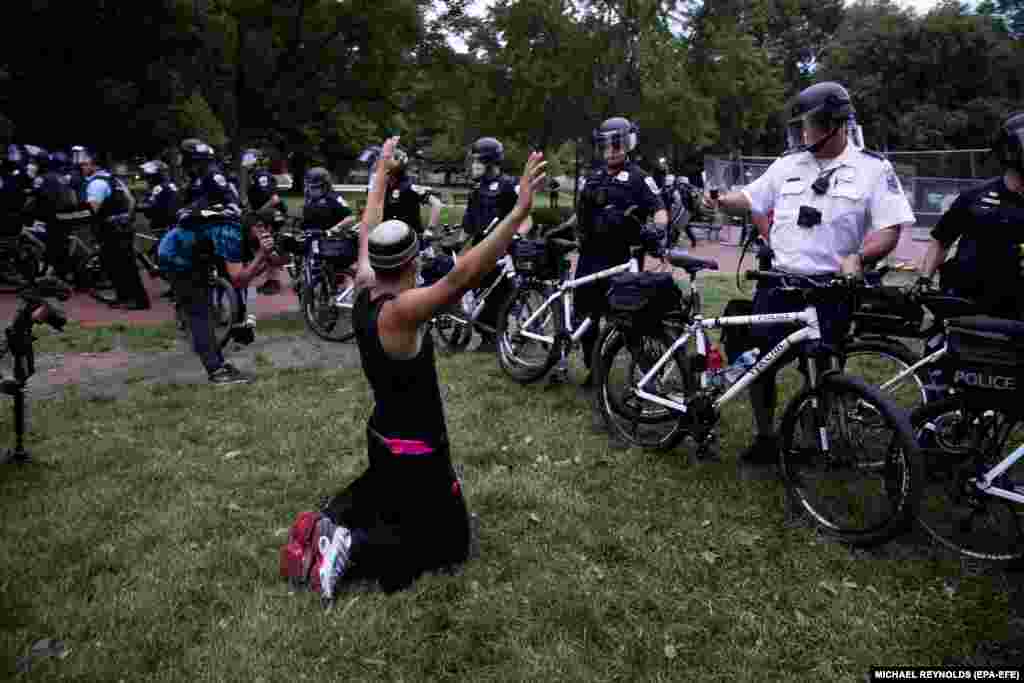 Чоловік стає на коліна перед поліцейськими, які охороняють парк Лафаєт, що навпроти Білого дому. Протестувальники намагалися знести пам&rsquo;ятник 7-му президентові США Ендрю Джексонові. Вашингтон, округ Колумбія, США