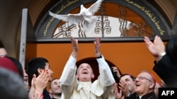 Pope Francis releases a dove as a symbol of peace during a meeting with the Chaldean community at the Catholic Church of St. Simon Bar Sabbae in Tbilisi on September 30.