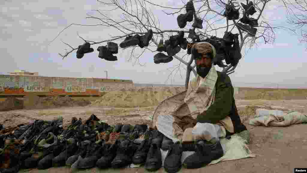 A man waits for customers while selling used shoes at his roadside stall in Quetta, Pakistan, on March 2. (Reuters/Naseer Ahmed)