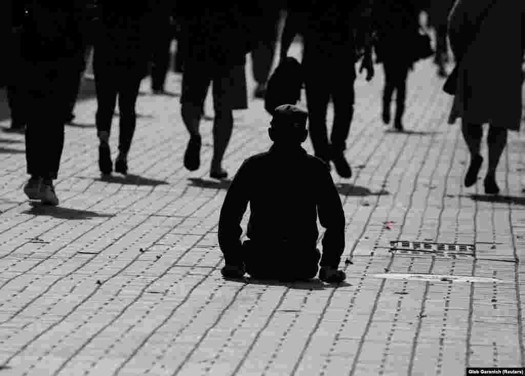 Një burrë me aftësi të kufizuara qëndron i ulur në një rrugë në Kiev të Ukrainës. (Reuters/Gleb Garanich)